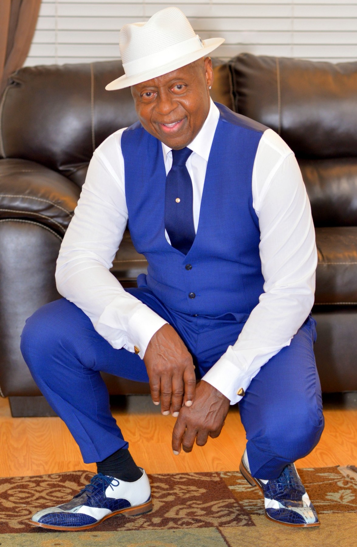 Seated blue waistcoat outfit with white fedora
